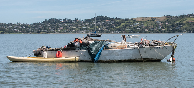 An abandoned boat coverage in garbage on the Bay