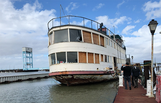 Decaying boat docked on Bay shoreline