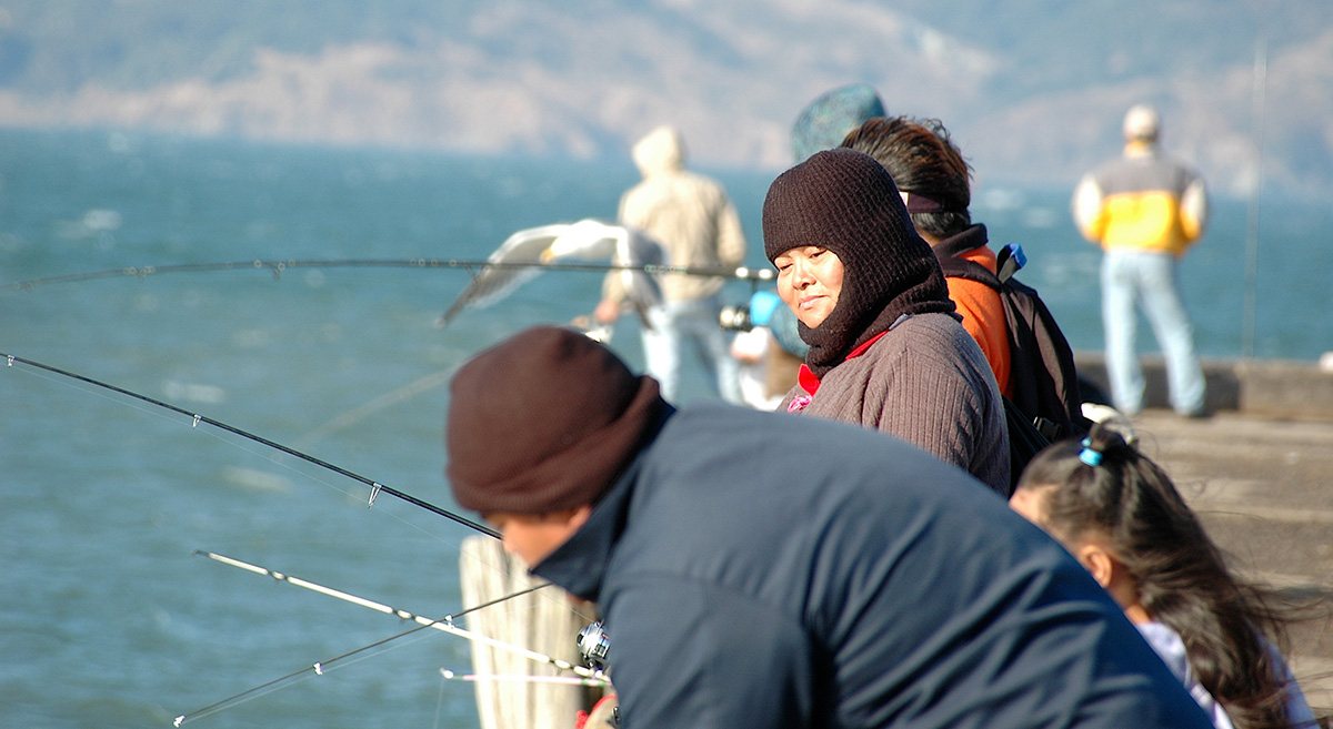 Fisherfolk fishing off a doc in the Bay