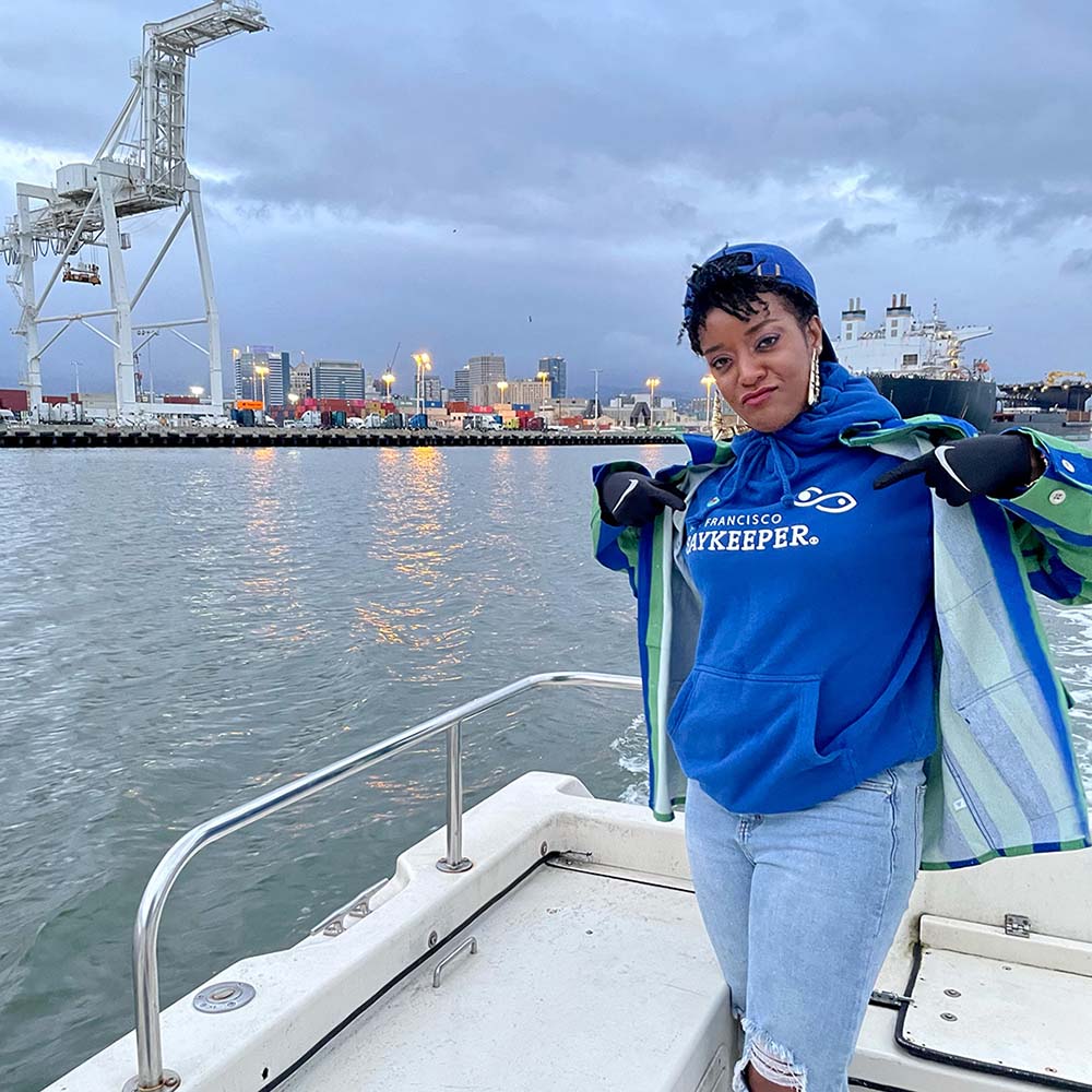 RyanNicole Austin aboard the Baykeeper boat with Oakland in background