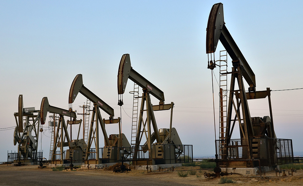 Oil drilling derricks at sunset 
