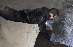 Baykeeper scientist Ian Wren takes water sample from sewage pipe