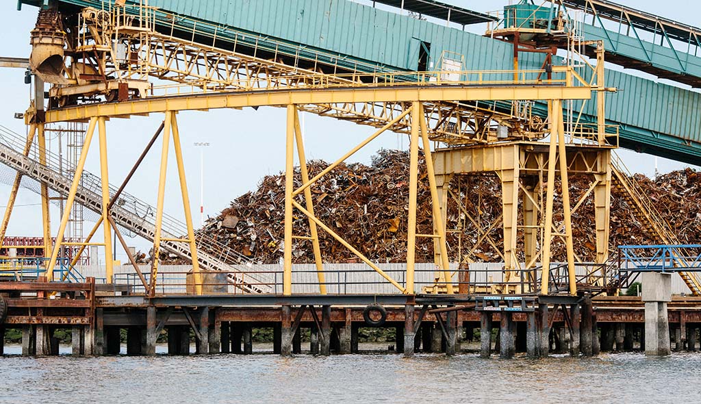 Industrial equipment and piles of metal along the shoreline