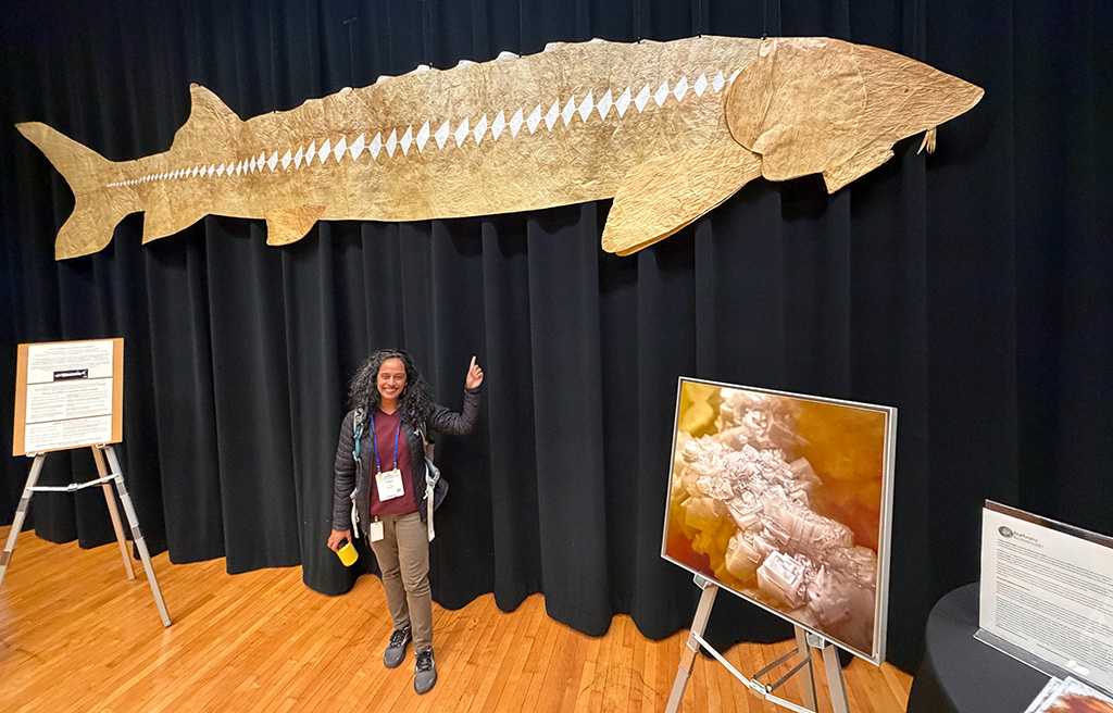 Cheryl Patel standing underneath giant art rendition of a sturgeon