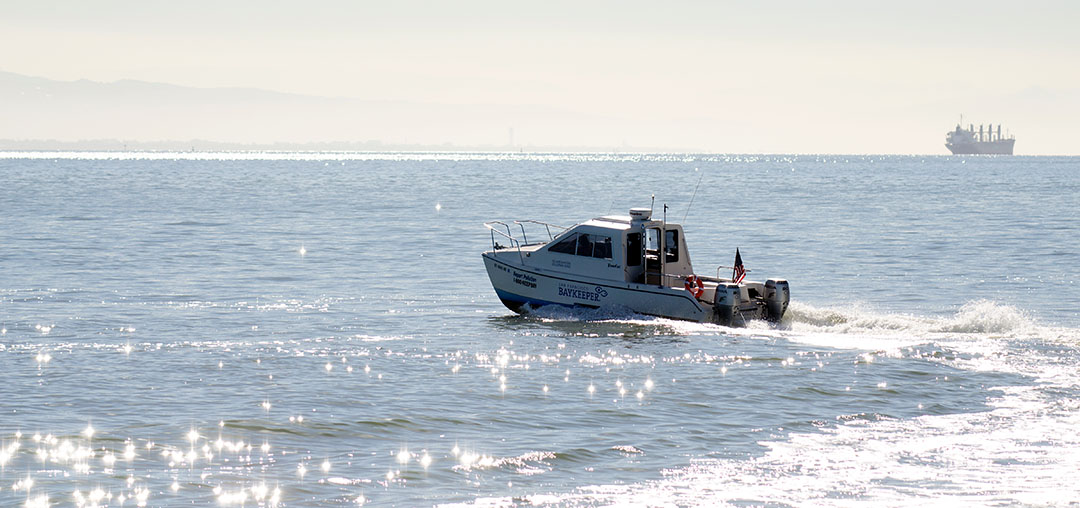 The Baykeeper boat zooming on the Bay with a wake behind it