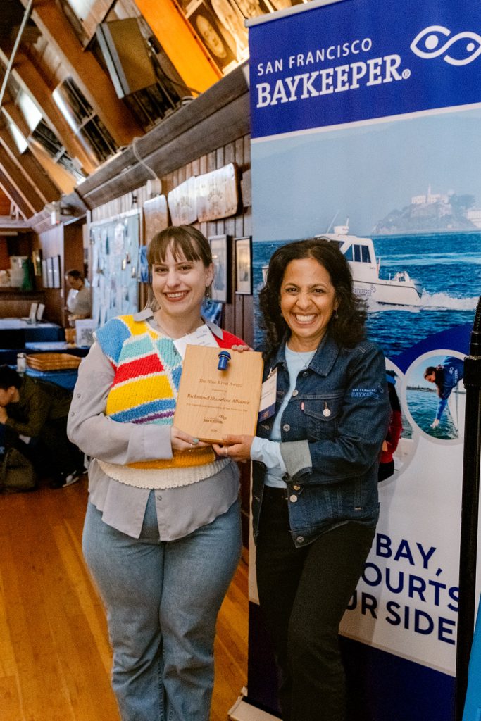 Two people holding an award plaque