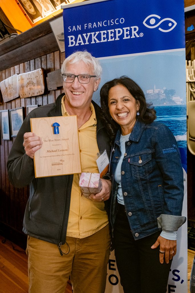 Two people holding an award plaque