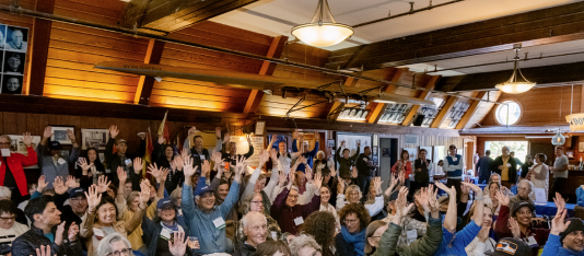 A group of people waving their hands at the Bay Celebration